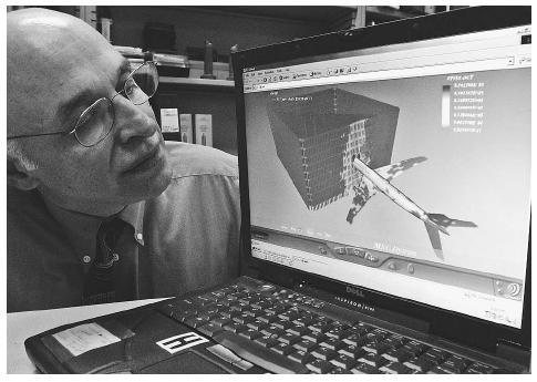 A steel structure expert at the University of California, Berkeley, studies a three-dimensional computer model of the airliner hitting the 96th floor of the World Trade Center. AP/WIDE WORLD PHOTOS.