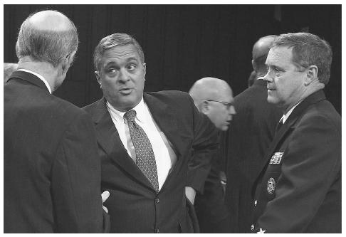Vice Admiral Thomas Wilson, right, confers with CIA Director George Tenet, center, after Tenet's testimony before the Senate Armed Servives Committee in March 2002, to discuss the threat to U.S. interests around the world by al Qaeda. AP/WIDE WORLD PHOTOS.