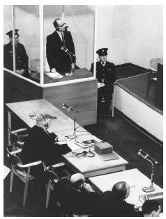 German Gestapo officer Adolf Eichmann listens to the guilty verdict read by the presiding judge as he stands in a bullet-proof glass enclosure in a Jerusalem court in 1961, during his trial for committing wartime atrocities against Jewish Europeans. AP/WIDE WORLD PHOTOS.