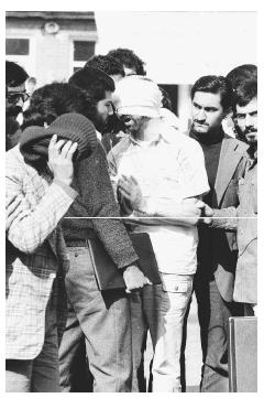 Blindfolded and with his hands bound, an American hostage is led by young militants in front of the United States Embassy in Tehran, November 8, 1979. AP/WIDE WORLD PHOTOS.