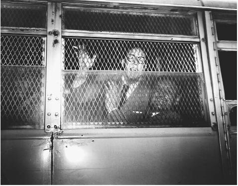 Dalton Trumbo, left, and John Howard Lawson, two screenwriters of the Hollywood Ten, smile and wave from inside a U.S. Marshal's van after receiving prison sentences for refusing to testify before the House Un-American Activities Committee. AP/WIDE WORLD PHOTOS.