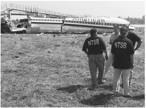 Investigators from the National Transportation Safety Board (NTSB) gather around the wreckage of American Airlines flight 1420, which crashed June 1, 1999. ©AFP/CORBIS.