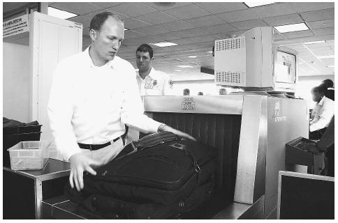 A Transportation Security Administration screener, left, loads luggage into an x-ray scanner at the Bismark, North Dakota, airport. More than 30,000 new Security Administration employees were hired for increased airport security screening since the September 11, 2001, terrorist attacks on the World Trade Center in New York. AP/WIDE WORLD PHOTOS.