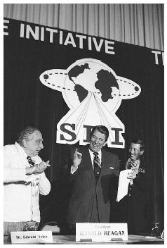 U.S. President Ronald Reagan is flanked by physicist Dr. Edward Teller, left, and Lt. Gen. James A. Abrahamson, director of Strategic Defense Initiative, as he arrives to address a conference marking the first five years of his "Star Wars" missile defense program in 1988. AP/WIDE WORLD PHOTOS.